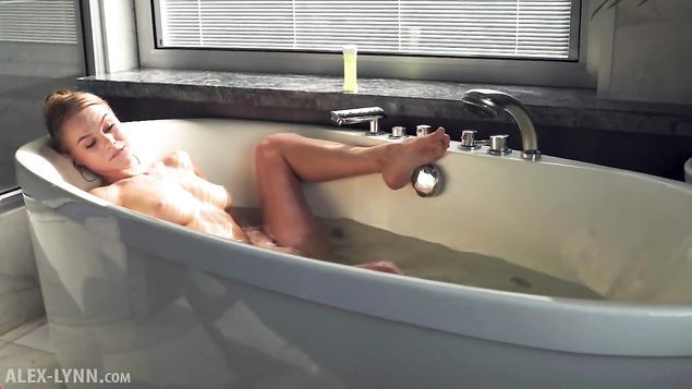 Красивая блондинка в ванной занимается мастурбацией